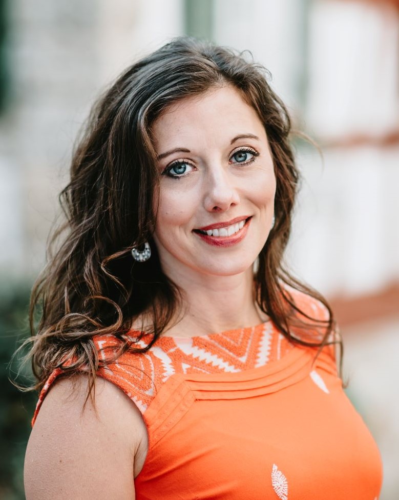A headshot of Sarah Cummins yoga therapist from Huntsville Alabama wearing orange 